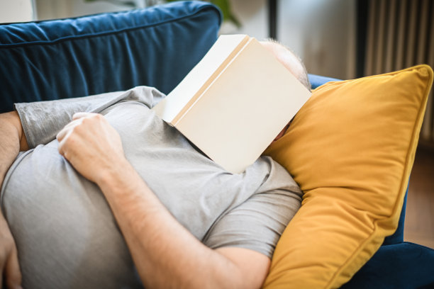 一个男人在房间里的蓝色沙发上休息图片下载