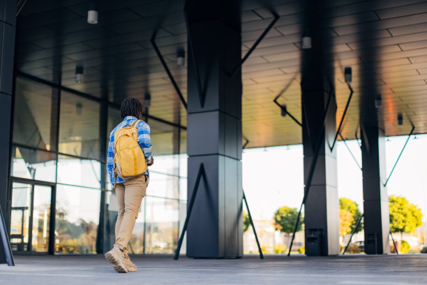 一个穿着格子衬衫的商人背着背包去上班图片下载