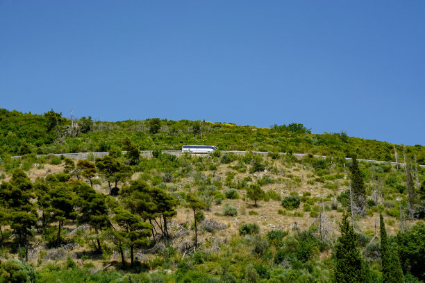 旅游巴士行驶在山路上图片下载