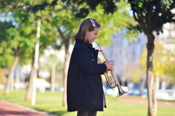 一个拿着小号的女孩在外面演奏图片下载