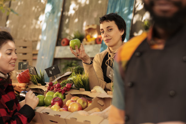 年轻的女农民向顾客展示各种有机水果图片下载