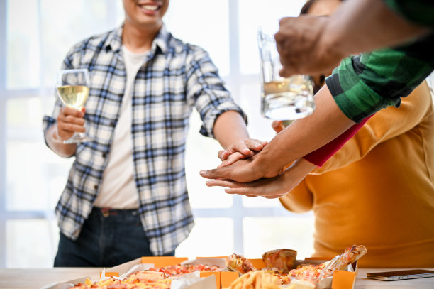 一群不同的亚洲朋友们把手放在一起，欢呼起来，庆祝他们的成功图片下载