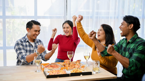 一群喜出望外的亚洲朋友笑着、尖叫着、欢呼着，在晚会上庆祝胜利。图片下载