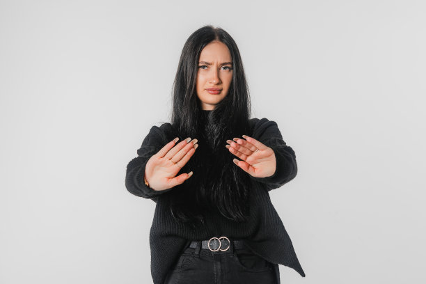 阻止它。年轻女子站在白色背景下，看着镜头，用手做“不”的手势。严肃的长发女孩不赞成史密斯、禁止、忌讳手势图片下载