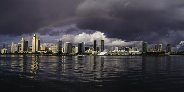 彩虹在圣地亚哥市中心的天际线和摩天大楼，浪漫的城市景观，和戏剧性的云景图片下载