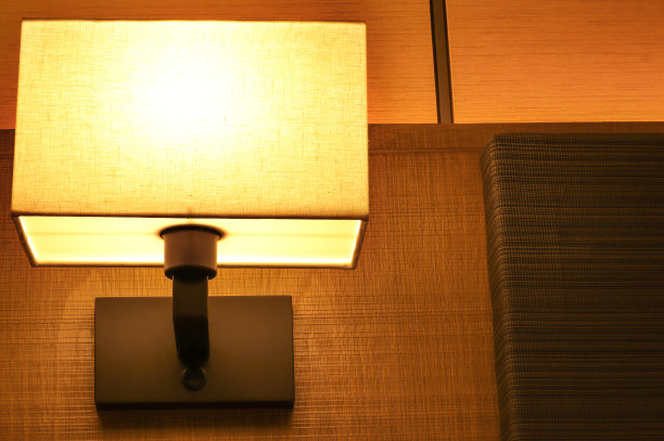 近距离的照明灯在昏暗的卧室在夜间在豪华酒店。旅行和放松概念图片下载