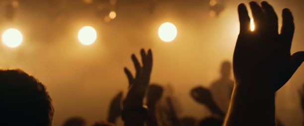 背景模糊的大型活动中举手的剪影图片下载