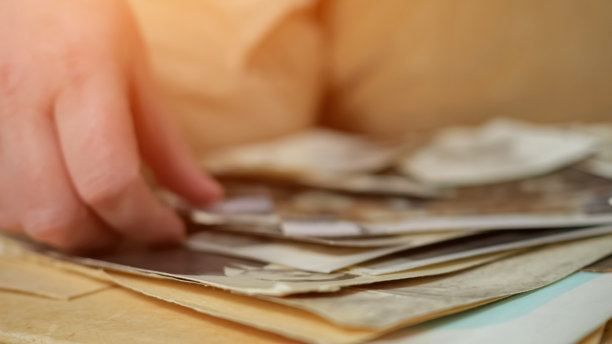 人们从相册中抓取并仔细检查旧照片图片下载