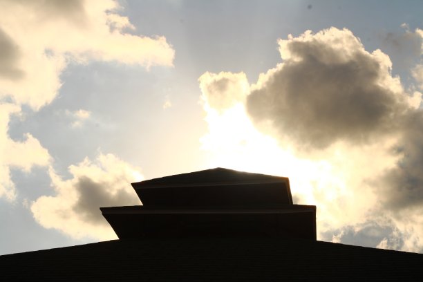 花式屋顶背光太阳。蓝天上的云图片下载