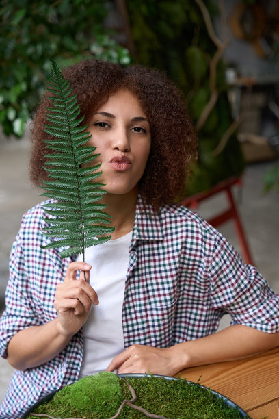 俏皮女子在车间制作绿色花道图片下载