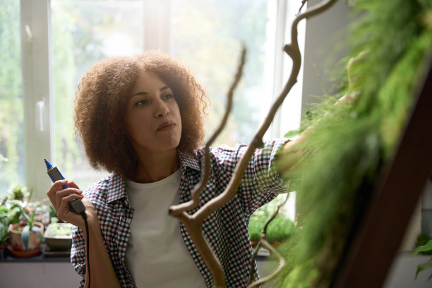 年轻女子在花店创造绿色成分图片下载