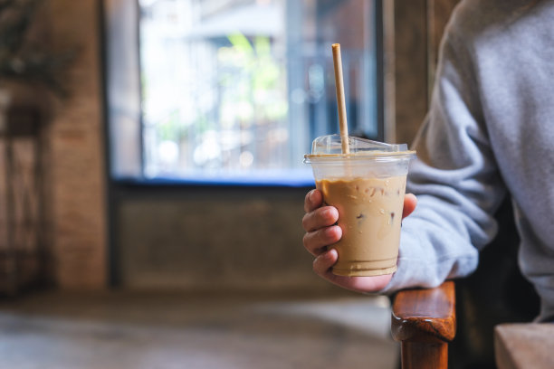 一个女人拿着一杯冰咖啡的特写图片图片下载
