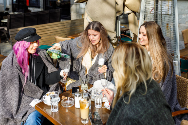 一群女性朋友正在露天城市咖啡馆享用香槟。图片下载