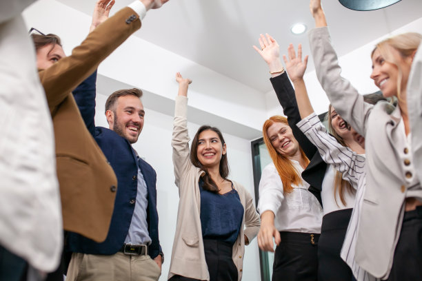 业务团队一起在办公室庆祝公司胜利，欢声笑语，兴奋的员工和同事在办公室欢呼雀跃。图片下载
