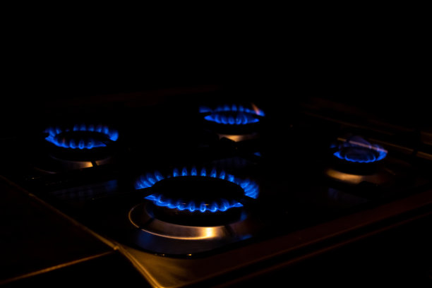现代家用烤箱。煤气炉上有四个燃烧着的蓝色火焰图片下载