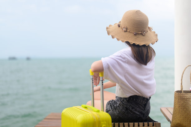 在酒店带行李箱的人，带黄色行李的快乐女旅行家，带大包小包的人，出国度假的快乐游客图片下载