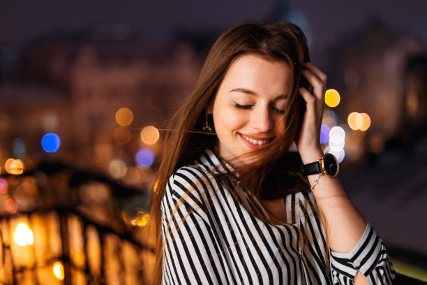 迷人的年轻女子在城市灯光背景的夜间艺术肖像。美丽的女孩，在城市灯光下的肖像。时尚风格的肖像。情感上的照片。图片下载