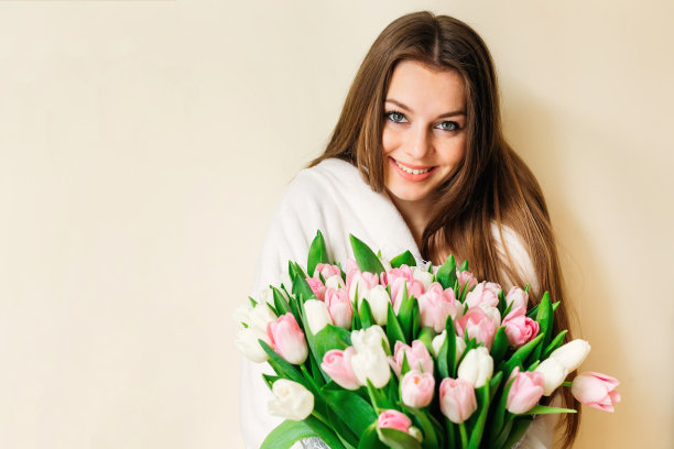一个可爱的女孩的肖像与一束精致的郁金香。图片下载