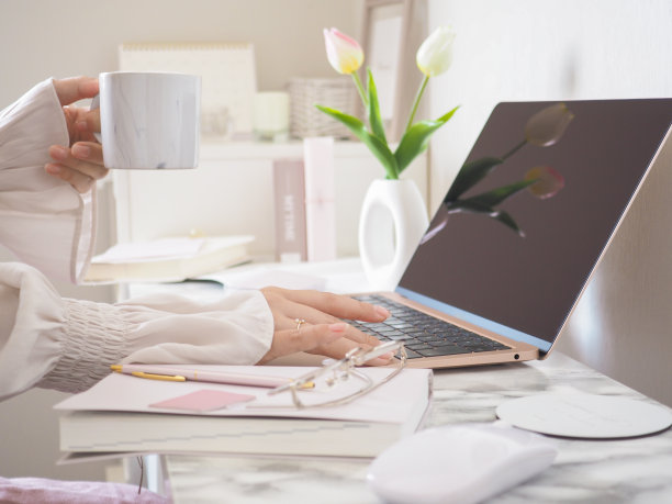 一位女士在时尚的办公桌前使用笔记本电脑工作图片下载