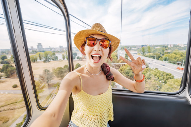 一个旅行博主女孩在缆车上用智能手机自拍，可以看到科隆市的景色图片下载
