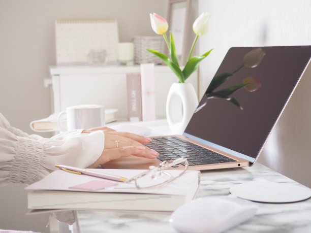 一位女士在时尚的办公桌前使用笔记本电脑工作图片下载