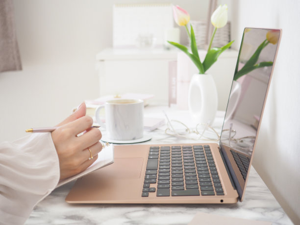 一位女士在时尚的办公桌前使用笔记本电脑工作图片下载