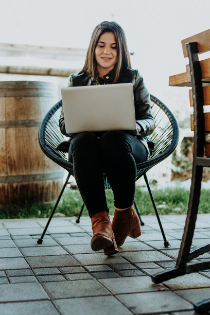 迷人的女人坐在现代咖啡店和笔记本电脑上工作图片下载