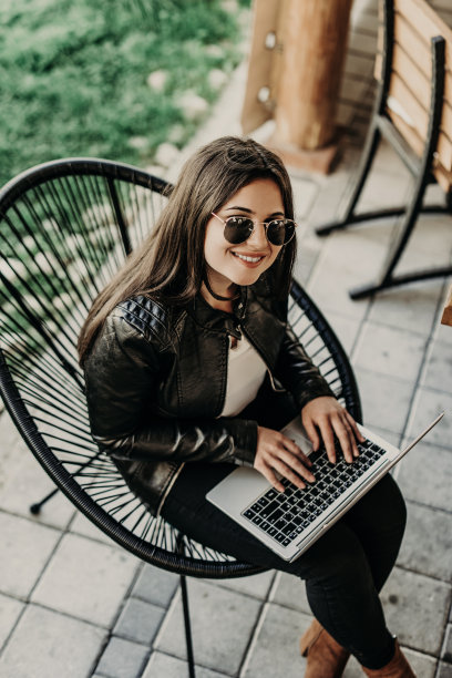 迷人的女人坐在现代咖啡店和笔记本电脑上工作图片下载