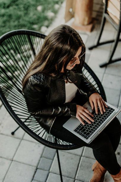 迷人的女人坐在现代咖啡店和笔记本电脑上工作图片下载