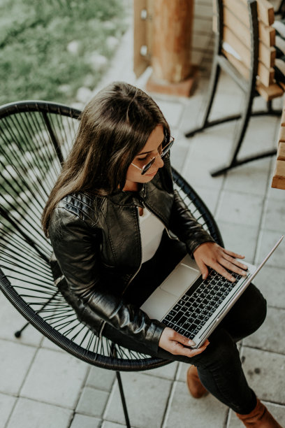 迷人的女人坐在现代咖啡店和笔记本电脑上工作图片下载