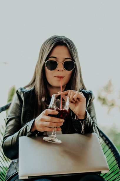 迷人的女人坐在现代咖啡店和笔记本电脑上工作图片下载