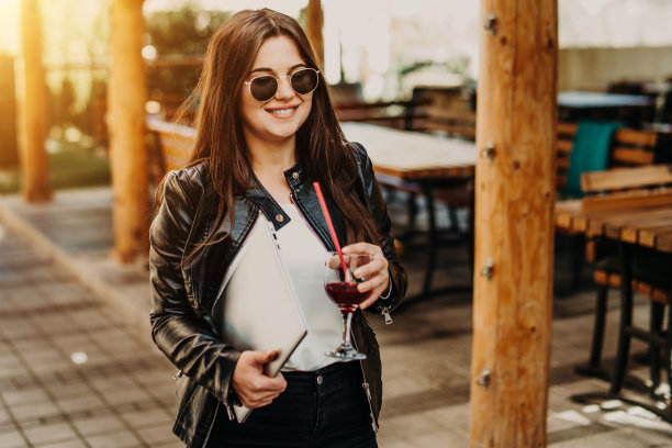 一个女商人拿着笔记本电脑走在街上图片下载