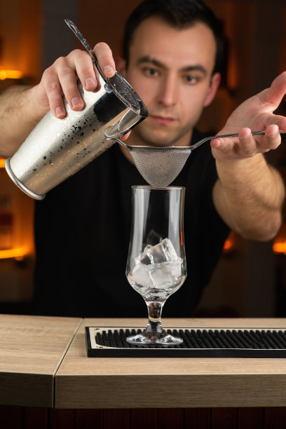 夜总会里，专业的酒保正在用摇酒器调制鸡尾酒。图片下载