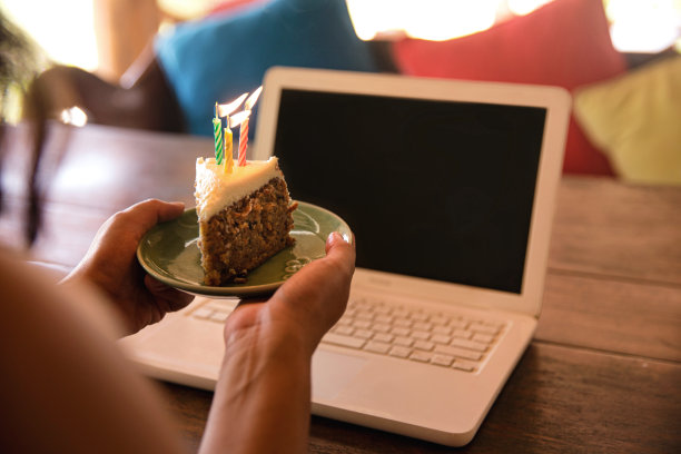 不知名的女性手拿一块生日蛋糕和点燃的蜡烛图片下载