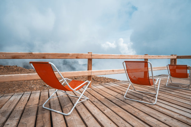 多云的阿尔卑斯山上的红色日光浴床图片下载