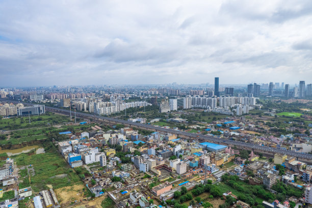 无人机在古尔冈上空拍摄的照片显示，季风云和光线落在挤满房屋的地面上，sohna高速公路田地和建筑周围的水池图片下载