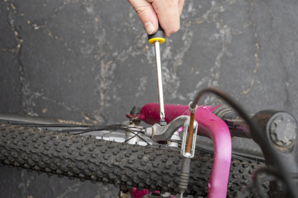 一个特写的男性手，使用螺丝刀工具调整和修理自行车曲柄总成图片下载