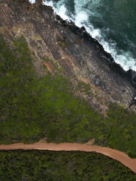 鸟瞰图，悬崖上狭窄的路径覆盖着大自然，靠近大海图片下载