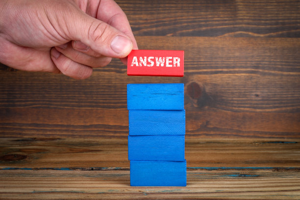 回答的概念。彩色的积木和一个人的手在木制纹理背景图片下载