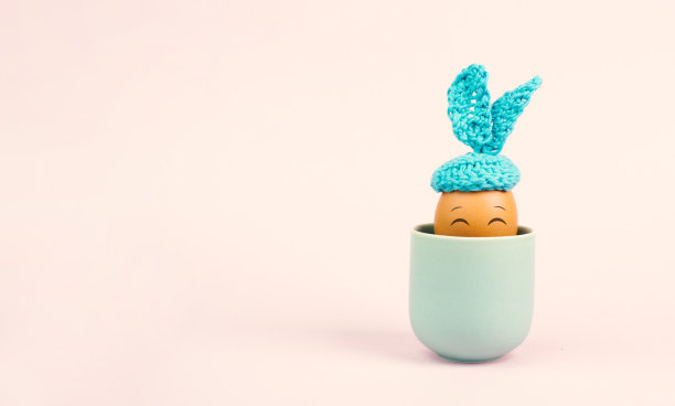 可爱的复活节兔子或兔子与微笑的鸡蛋脸在一个杯子，春节假期，贺卡图片下载