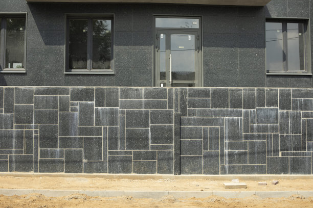 建筑物的底层。黑色瓷砖包层。新房子的窗户。图片下载