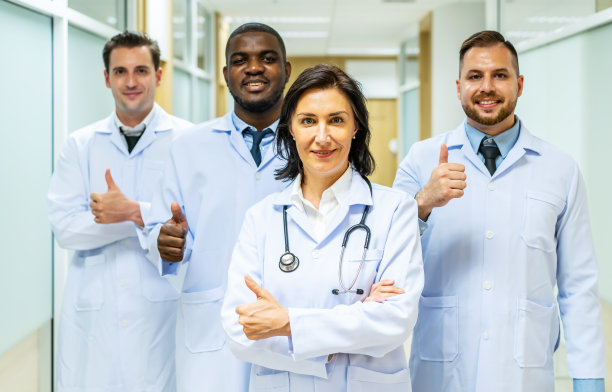 图为成功的医生团队站在医院里对着镜头微笑图片下载
