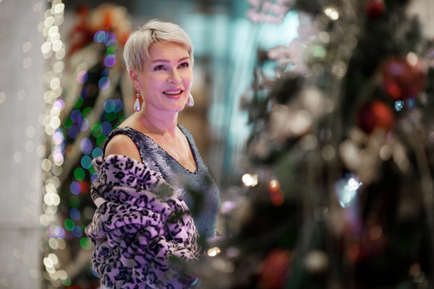 在圣诞或新年装饰的公共场所快乐的成熟女人的肖像图片下载
