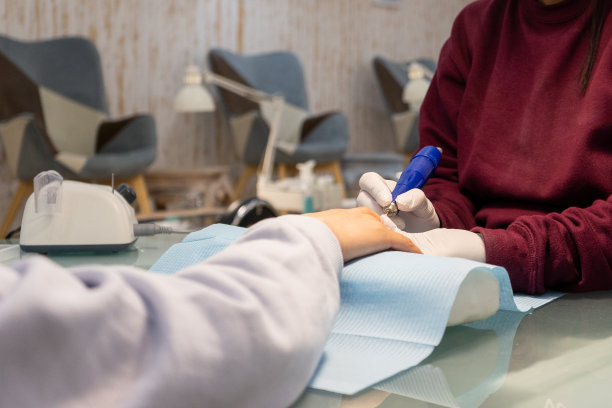 一个不认识的人开始用指甲抛光机给客户修指甲。图片下载