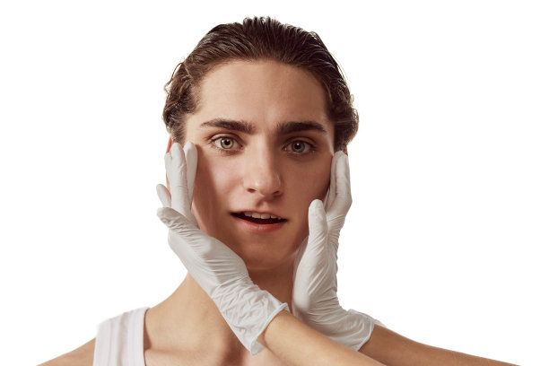 年轻男子访问美容师的肖像，在白色背景上隔离皮肤后进行护理。男性美的概念，整形手术，美容图片下载