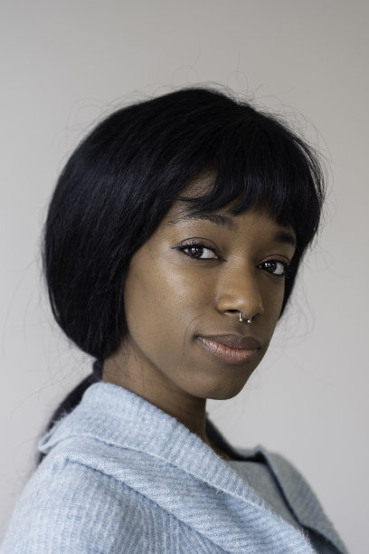 年轻的黑人非洲裔美国妇女与直发看着相机-垂直肖像图片下载