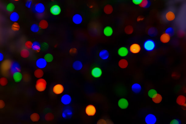 抽象的节日背景。圣诞树上的电子花环发出的彩色散焦灯。新年。图片下载