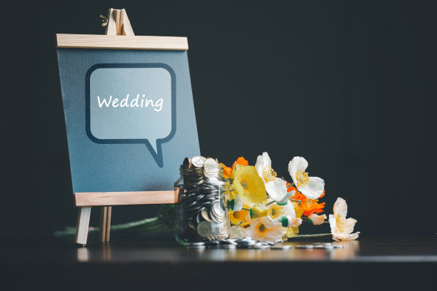 为婚礼省钱和策划婚礼概念。为家庭生活或婚姻生活制定可持续的财务目标。一排排上升的硬币上的微型婚礼，描绘了新家庭的储蓄或成长。图片下载