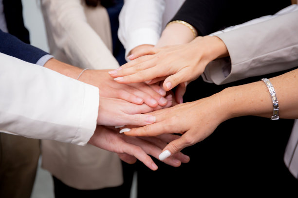 一群和谐的企业团队，男女携手共进，为企业的胜利和成功而奋斗;一群伙伴的团队，为成就而相聚和欢呼。图片下载