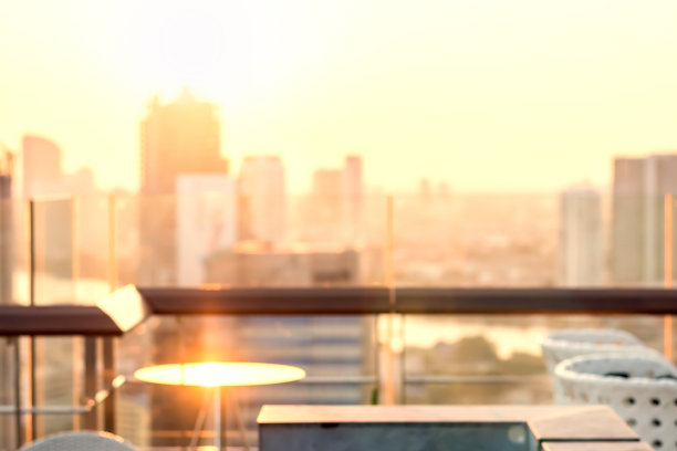 夏日太阳模糊城市屋顶视图背景黄金时间天空日落与城市景观办公楼景观模糊城市灯光天际线散景为晚会图片下载